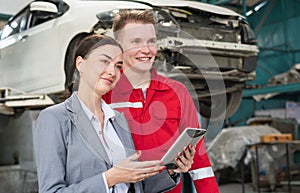 Female manager and car mechanic while working in auto repair shop, Woman at a car garage getting mechanical service, Car repair,