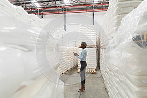 Female manager with digital tablet checking stocks in warehouse