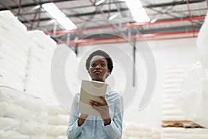 Female manager with digital tablet checking stocks in warehouse