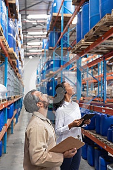 Female manager and male staff checking stocks in warehouse