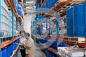 Female manager and male staff discussing over clipboard in warehouse