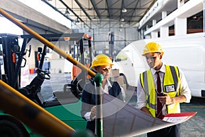 Female manager and male supervisor discussing over inventory chart in warehouse