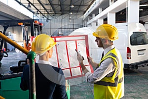 Female manager and male supervisor discussing over inventory chart in warehouse