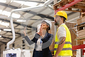 Female manager talking with foreman. Warehouse, production worker preparing products for shipment. Woman quality