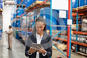 Female manager using digital tablet in warehouse
