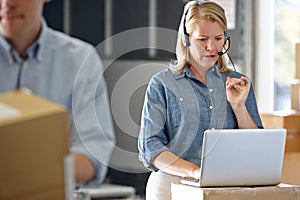 Female Manager Using Headset In Distribution Warehouse