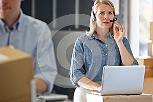 Female Manager Using Headset In Distribution Warehouse