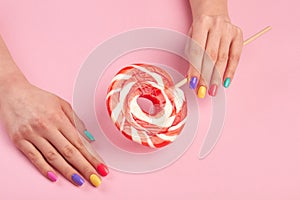 Female manicured hands with lollipop.