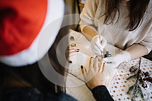 Female manicurist with brush painting on fingernails