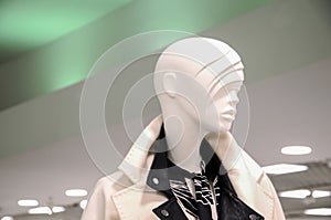 Female mannequin in elegant coat in the sales area of a women`s clothing retail store