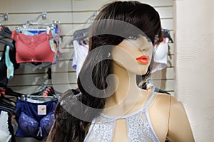 Female mannequin in a wig in the shop on the background of underwear