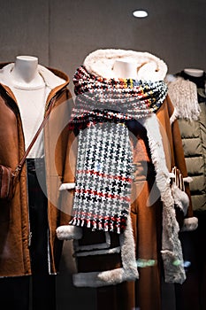 Female mannequins demonstrate brown coats in a women`s store in store window show autumn winter collection . Standing