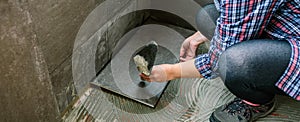 Female manual worker laying a new tile floor