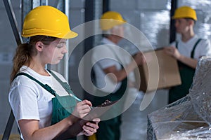 Female manufacturing labourer holding clipboard