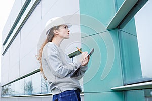 Female manufacturing labourer outdoors holding clipboard