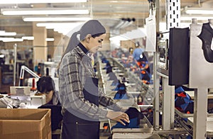 Female manufacturing worker making shoe at production line of footwear factory