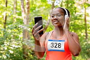female marathon runner with headphones and phone