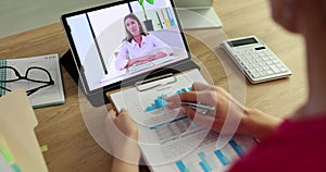 Female marketer discusses a financial report with a colleague during a video call