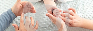 Female massage therapist teaching young mother how to massage her newborn baby boy. Baby massage concept. Cropped shot.