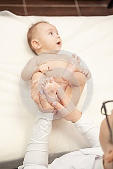Female masseur doing baby massage for infant baby child.
