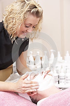 Female masseuse giving client facial