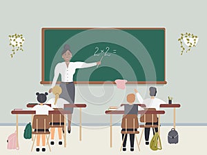 Female math teacher explaining multiplication to elementary school pupils