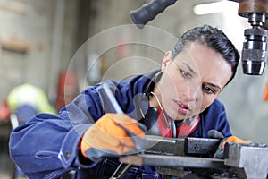 female mechanic apprentice working on milling machine