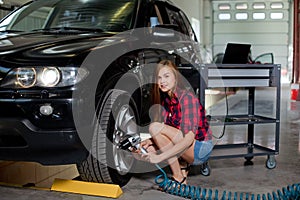 Female mechanic changing tire with air impact wrench