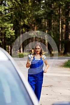 Female mechanic changing tire with wheel wrench photo