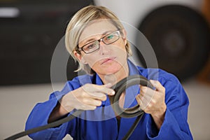 Female mechanic with distribution belt in hands