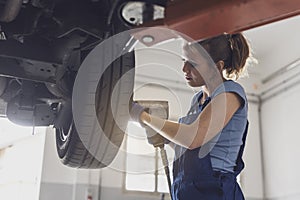 Female mechanic doing a wheel replacement