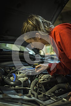 Female mechanic inspecting car engine