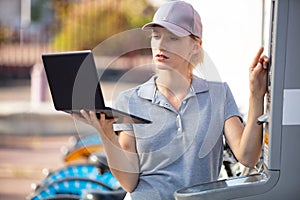 female mechanic with laptop outdoors
