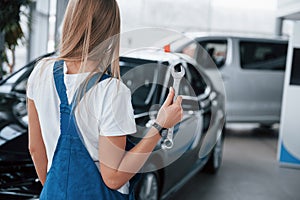 Female mechanic. Nice blonde woman repairer is on her work. Indoors at car shop