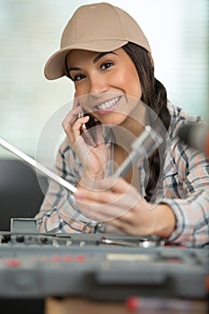 Female mechanic with socket set using smartphone