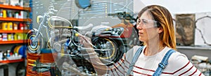 Female mechanic touching hud panel screen with augmented reality hologram to review motorcycle