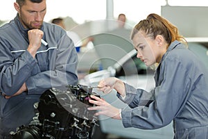 female mechanic using spanner on engine
