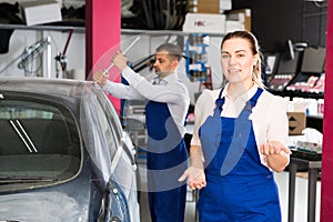 Female mechanic welcoming in car workshop