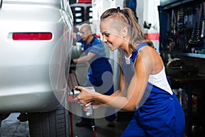 Female mechanic working on car tyre service