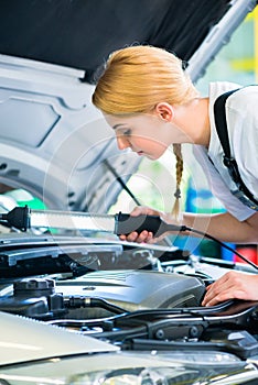 Female mechanic working in car workshop