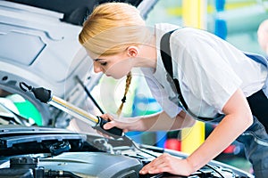 Female mechanic working in car workshop