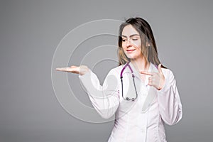 Female medical doctor showing copy space. Woman in white professional uniform with stethoscope on neck.