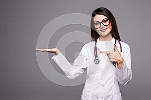 Female medical doctor showing copy space. Woman in white professional uniform with stethoscope on neck invite people to clinic hos