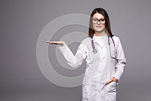 Female medical doctor showing copy space. Woman in white professional uniform with stethoscope on neck invite people to clinic hos