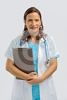 Female medical doctor wearing white medical gown with stethoscope holding clip board