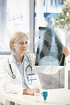 Female medical expert analysing x-ray image photo
