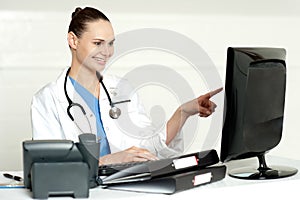 Female medical expert pointing at computer screen