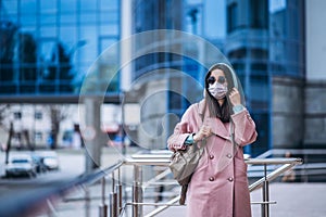 Female in medical mask outdoors in the empty city. Health protection and prevention of virus outbreak, coronavirus, COVID-19,