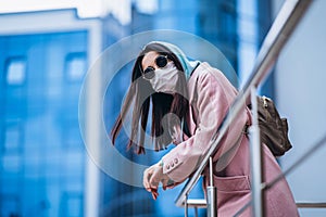 Female in medical mask outdoors in the empty city. Health protection and prevention of virus outbreak, coronavirus, COVID-19,