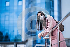 Female in medical mask outdoors in the empty city. Health protection and prevention of virus outbreak, coronavirus, COVID-19,